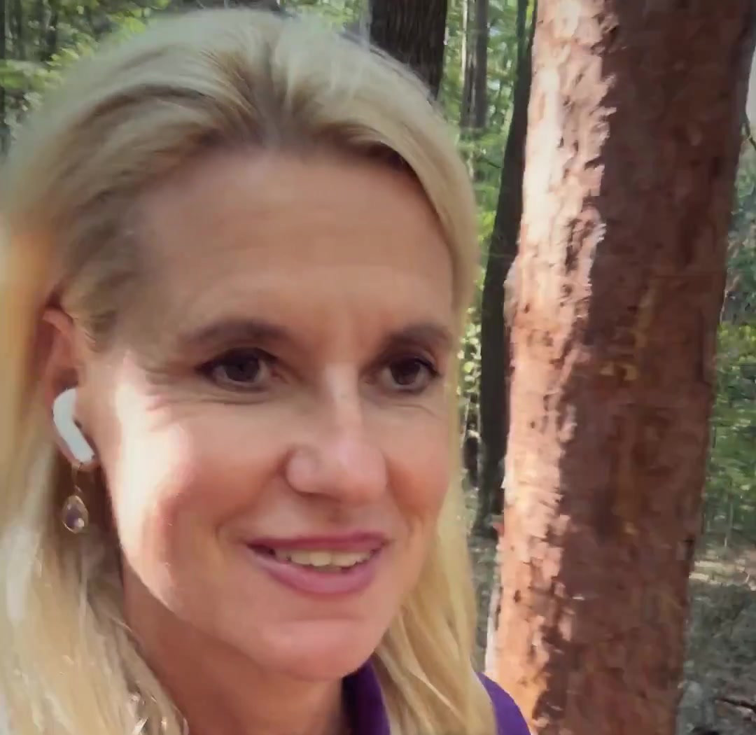 Birgit Quirchmayr beim Spazierengehen im Wald, mit Kopfhörern im Ohr
